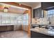 Kitchen featuring gray cabinets, granite countertops, stainless steel appliances, and an attached sunroom with ample natural light at 2022 Newton St, Columbus, IN 47201