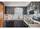 Kitchen with gray cabinets, granite countertops, stainless steel appliances and white backsplash, creating a modern aesthetic at 2022 Newton St, Columbus, IN 47201