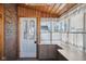 Bright sunroom featuring brick accent wall, wood ceiling, large windows, and ample counter space at 2022 Newton St, Columbus, IN 47201