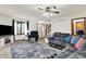 Open-concept living room with hardwood floors, a gray sectional, a brick fireplace, and staircase at 211 Deborah Ln, Whiteland, IN 46184