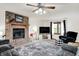 Living room with a brick fireplace, mounted television, ceiling fan, and comfortable furniture at 211 Deborah Ln, Whiteland, IN 46184
