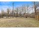 Spacious backyard with fenced perimeter, and waterfront view featuring a pond and firepit seating area at 2323 Chaucer Dr, Columbus, IN 47201