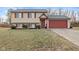 Charming home featuring red shutters, a red garage door, and a well-maintained front lawn at 2323 Chaucer Dr, Columbus, IN 47201