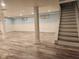 Finished basement with modern flooring, wainscoting, support beams, and stairs to the upper level at 2441 Northview Ave, Indianapolis, IN 46220