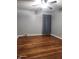 Bedroom with hardwood floors, light gray walls, and a window with a gray curtain at 2441 Northview Ave, Indianapolis, IN 46220