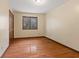 Empty bedroom featuring hardwood floors and window at 252 N Raceway Rd, Indianapolis, IN 46234