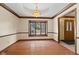 Empty dining room boasting hardwood floors, decorative trim, and a large window at 252 N Raceway Rd, Indianapolis, IN 46234