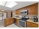 Traditional kitchen with wood cabinets, stainless steel appliances, and tile flooring at 252 N Raceway Rd, Indianapolis, IN 46234