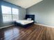 Bedroom with grey walls, wood floors, a bed, and a large window with a view of a lake at 254 Halldale Dr, Whiteland, IN 46184