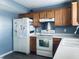 Functional kitchen featuring white appliances, wood cabinets, and a stainless steel vent hood at 254 Halldale Dr, Whiteland, IN 46184