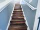 Stylish staircase featuring wood treads, white risers, and a matching white handrail at 254 Halldale Dr, Whiteland, IN 46184