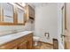 Vintage-style bathroom featuring a wood vanity, white fixtures, and bright overhead lighting at 2818 S Irwin St, Indianapolis, IN 46203