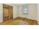This bedroom features wood floors, a window, and a closet with a wooden door at 2818 S Irwin St, Indianapolis, IN 46203