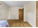 A sunlit bedroom features hardwood floors, white walls, and a wooden door at 2818 S Irwin St, Indianapolis, IN 46203