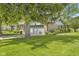 A single-story brick home featuring an attached two-car garage and mature trees on a well-manicured lawn at 2818 S Irwin St, Indianapolis, IN 46203