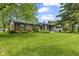Charming single-story brick home featuring a well-manicured lawn, mature trees, and an attached two-car garage at 2818 S Irwin St, Indianapolis, IN 46203