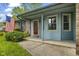 A cozy front porch area with a red door, brick accents, and lush greenery at 2818 S Irwin St, Indianapolis, IN 46203