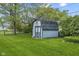 A sturdy, wood-paneled shed with a gable roof sits on a lush green lawn, offering ample outdoor storage at 2818 S Irwin St, Indianapolis, IN 46203