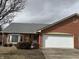 Charming brick home featuring an attached two-car garage, a well-maintained lawn, and a cozy bay window at 320 Lakewood Ct, Avon, IN 46123