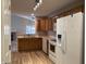 Spacious kitchen with wooden cabinets, appliances, and a breakfast bar opening to a living area at 320 Lakewood Ct, Avon, IN 46123