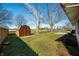 Large backyard with a storage shed, manicured lawn, and partial view of the house at 3932 Villa Dr, Columbus, IN 47203