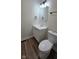 Clean bathroom features a modern vanity with white countertop, toilet, wood-look floors, and updated lighting at 4713 Calhoun St, Indianapolis, IN 46203