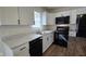 Well-lit kitchen boasts white cabinets, modern appliances, stainless steel sink and sleek black hardware at 4713 Calhoun St, Indianapolis, IN 46203