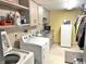 Bright laundry room with a washing machine, dryer, sink, storage cabinets, and a small refrigerator at 505 Birch St, Beech Grove, IN 46107