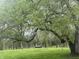 Spacious backyard featuring mature trees and green grass with a shed and a white fencing at 5533 Wilson Way, Jamestown, IN 46147