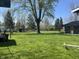Expansive backyard with lush green grass, mature trees, and partial view of the home's exterior at 5533 Wilson Way, Jamestown, IN 46147