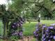 Picturesque backyard landscape with colorful flowers, angel statue and a wooden fence at 5533 Wilson Way, Jamestown, IN 46147