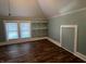 Bedroom with slanted ceiling, light blue walls, wood floors, shelving, and two windows at 5533 Wilson Way, Jamestown, IN 46147