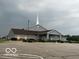 Charming church with a covered entrance, grey exterior, large parking lot, and a steeple with a cross at 5533 Wilson Way, Jamestown, IN 46147