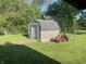 Outdoor storage shed featuring grey siding and asphalt shingles situated on a well-maintained lawn with mature trees at 5533 Wilson Way, Jamestown, IN 46147