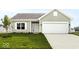 Charming single-story home boasts a well-manicured lawn, attached garage, and neutral siding at 632 Derek Ln, Trafalgar, IN 46181