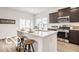 Modern kitchen featuring stainless steel appliances, a center island with seating, and dark wood cabinets at 632 Derek Ln, Trafalgar, IN 46181