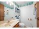 Charming half-bathroom with seashell decor, vanity with countertop sink, and decorative mirror that adds to the room's character at 6440 Watercrest Way, Indianapolis, IN 46278