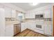 Well-maintained kitchen featuring white cabinets, appliances, and tile accents at 6440 Watercrest Way, Indianapolis, IN 46278