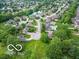 Aerial view of a residential neighborhood with lush greenery, a small pond, and well-maintained homes at 651 Rylan Cir, Greenwood, IN 46142