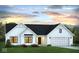 Charming single-story home with white siding, a black roof, and an attached two car garage at 651 Rylan Cir, Greenwood, IN 46142
