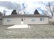 Cozy home featuring a wood deck, beige siding, and trimmed evergreen shrubs in backyard at 7807 Inverness Dr, Indianapolis, IN 46237