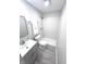 Modern bathroom featuring a walk-in shower with white textured tile and updated gray vanity at 7807 Inverness Dr, Indianapolis, IN 46237