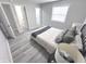 Bright bedroom featuring gray walls, wood-look flooring, and natural light from the large window at 7807 Inverness Dr, Indianapolis, IN 46237