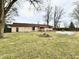 Large backyard featuring a patio, fire pit, and garden bed at 812 Madison St, Frankton, IN 46044