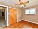 Bedroom featuring hardwood floors, a ceiling fan, a closet, and a window at 812 Madison St, Frankton, IN 46044