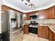 Well-lit kitchen features stainless steel appliances, range, microwave, and wood cabinets at 812 Madison St, Frankton, IN 46044
