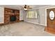 Cozy living room showcasing a brick fireplace, plush carpeting, and an abundance of natural light at 812 Madison St, Frankton, IN 46044