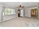 Spacious living room with plush carpeting, ceiling fan, and a large window for natural light at 812 Madison St, Frankton, IN 46044