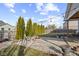 Charming backyard featuring a fire pit, gravel area, mature trees and string lights at 8352 Alcona Dr, Indianapolis, IN 46237