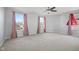 Spacious bedroom featuring multiple large windows, neutral carpeting, and a modern ceiling fan at 8352 Alcona Dr, Indianapolis, IN 46237